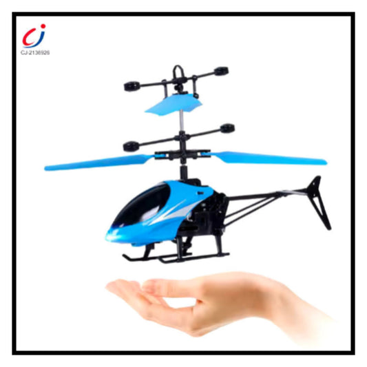 Blue and black remote control hand induction hovering toy helicopter flying above open hand on white background