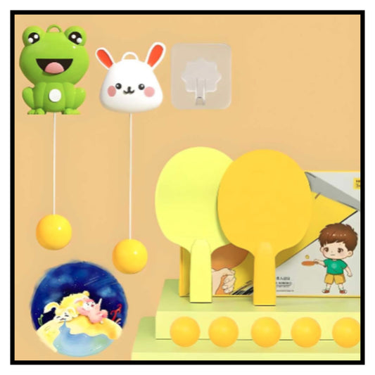 Yellow indoor table tennis trainer set with frog and rabbit hanging ball targets, paddles and balls, with product box against orange background