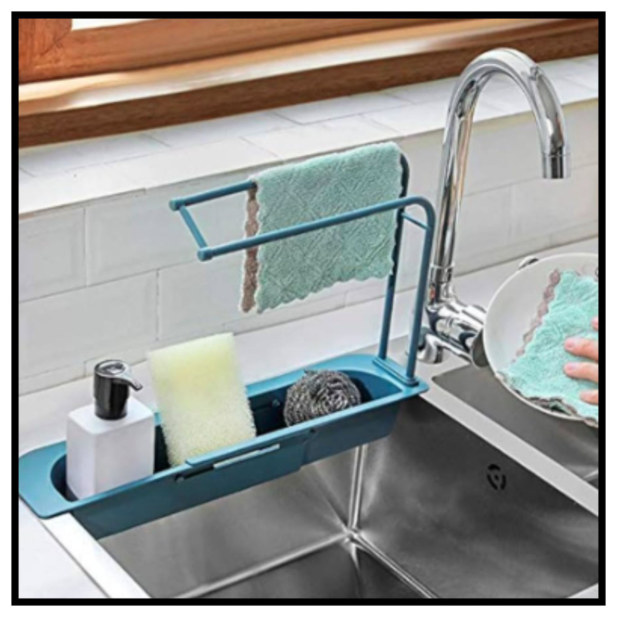 Blue kitchen sink sponge holder organizer tray mounted on a stainless steel sink holding soap dispenser sponge scrubber and hanging towel cloth with faucet in background