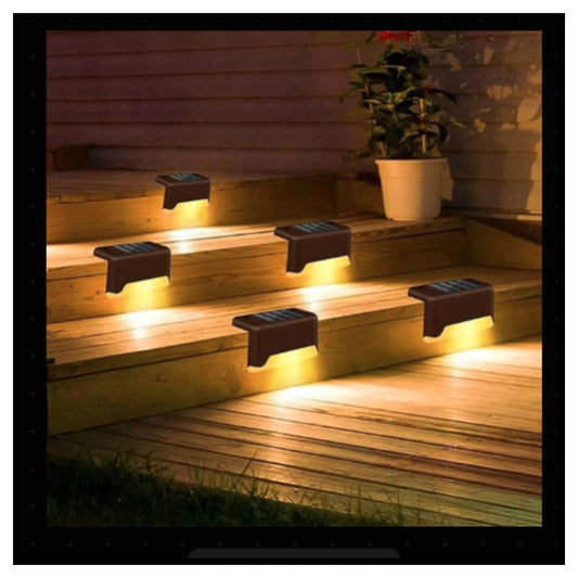 Five solar-powered outdoor step lights illuminating wooden deck stairs at night with a potted plant on the upper step