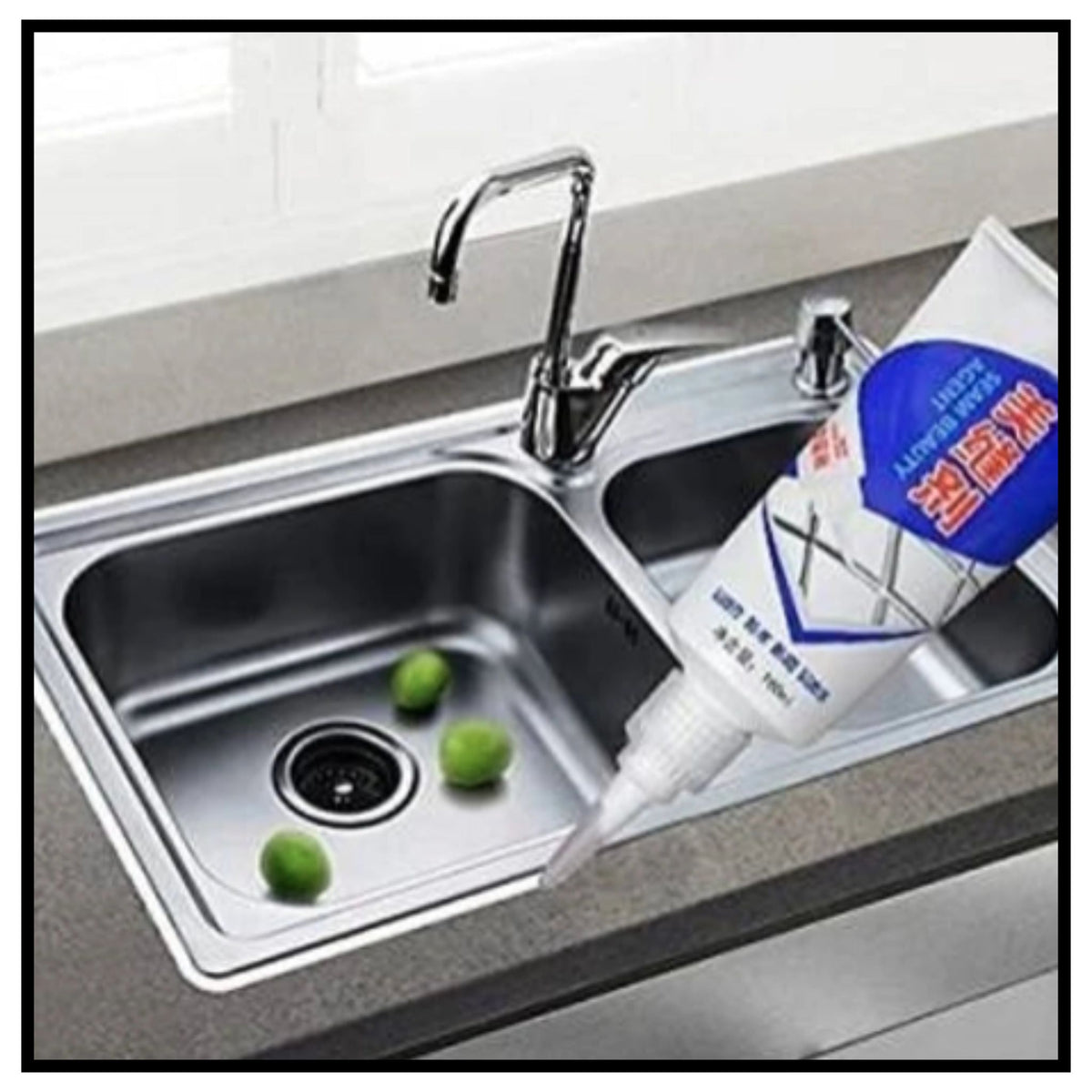 Tiles gap filler tube applying white filler to kitchen sink gap near stainless steel faucet with lime fruits in sink
