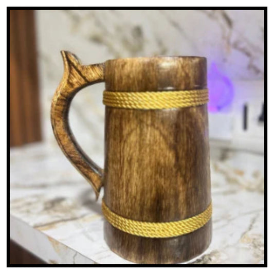 Wooden beer stein mug with carved handle and two braided rope bands on marble patterned surface